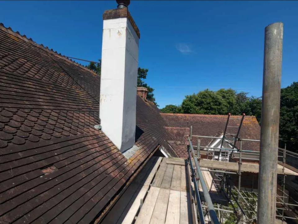 Before: the old worn clay-tile roof and chimney